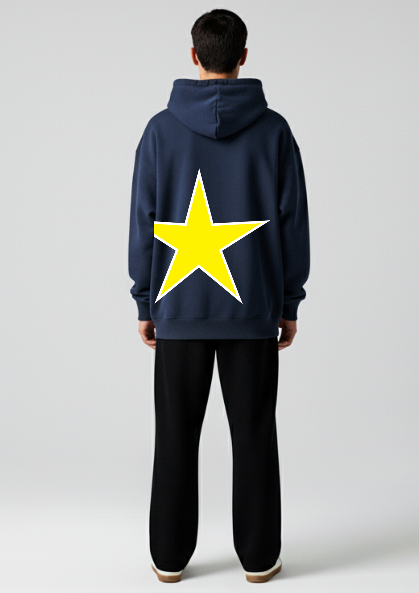 Person wearing a navy oversized hoodie with a yellow star on the back